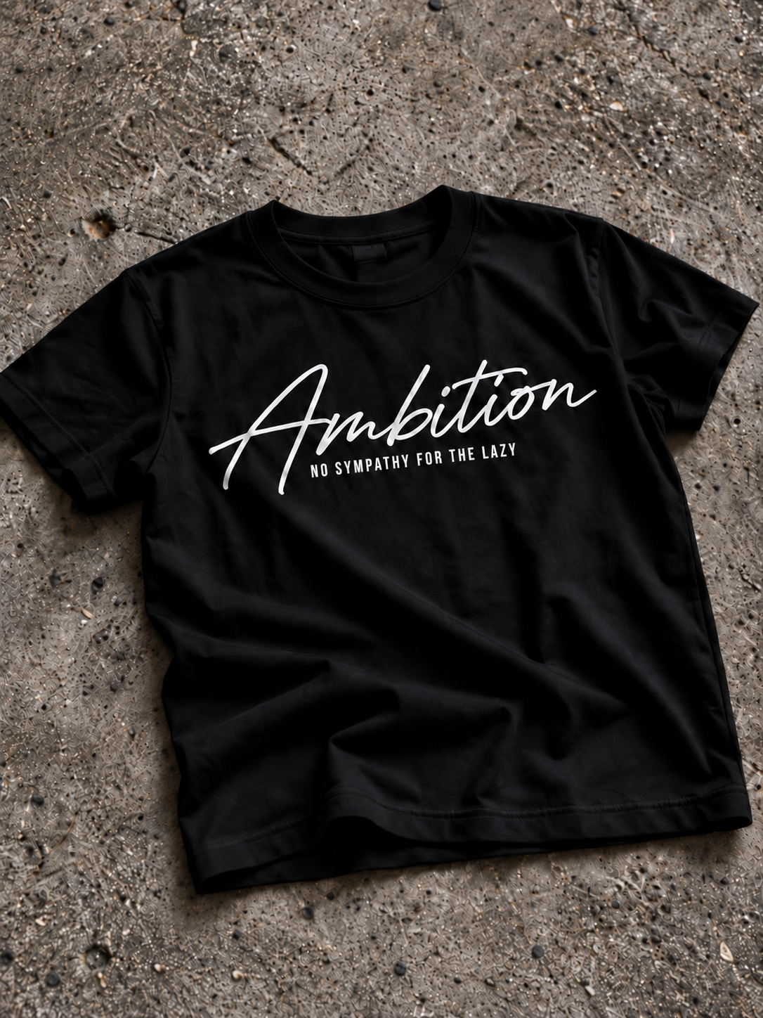 Black Ambition T-shirt on textured stone.